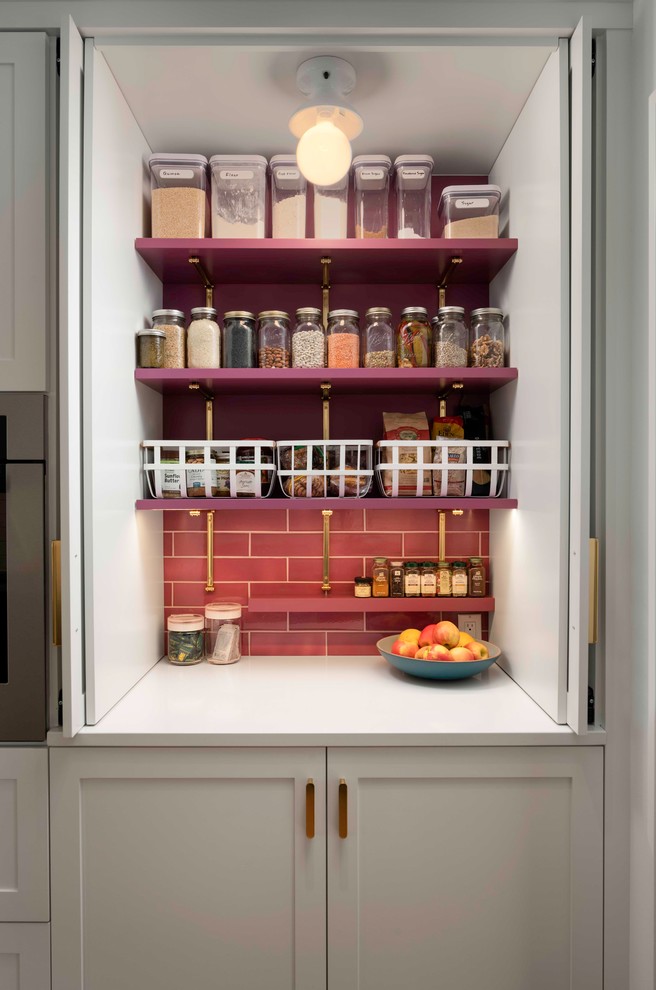 Mid-sized transitional galley medium tone wood floor kitchen pantry photo in Portland with an undermount sink, recessed-panel cabinets, white cabinets, quartzite countertops, pink backsplash, ceramic backsplash, stainless steel appliances, an island and white countertops