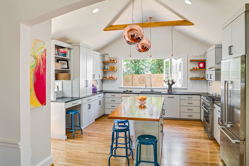 Design ideas for a small farmhouse u-shaped kitchen/diner in Atlanta with a submerged sink, flat-panel cabinets, grey cabinets, granite worktops, white splashback, ceramic splashback, stainless steel appliances, medium hardwood flooring and an island.