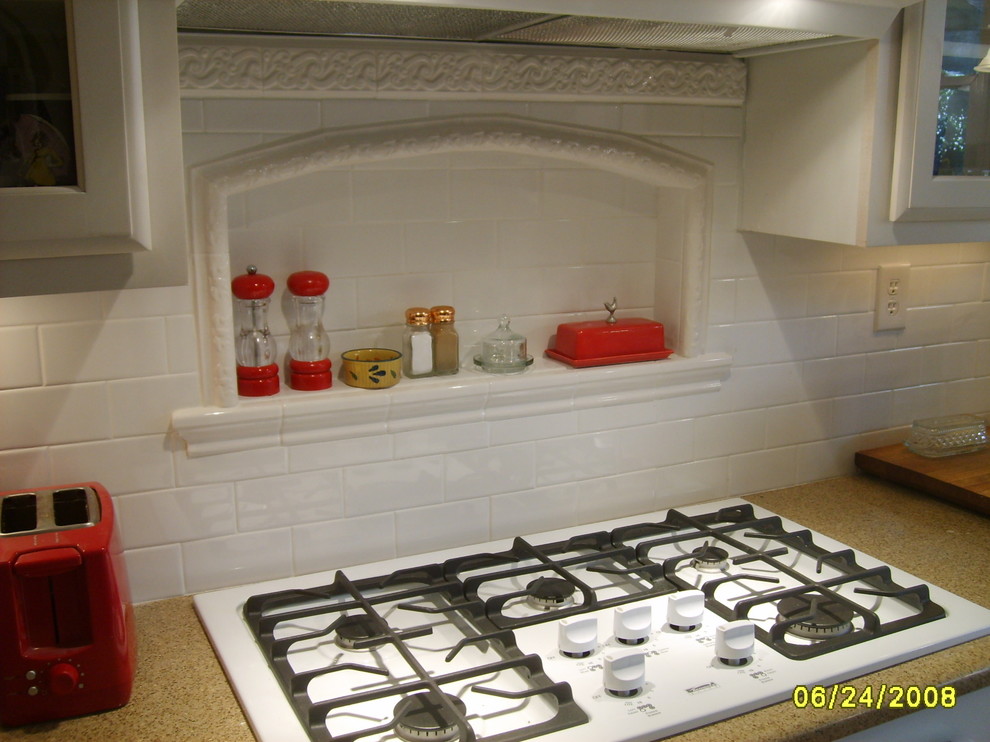 Inredning av ett klassiskt kök, med en rustik diskho, luckor med infälld panel, vita skåp, bänkskiva i kvartsit, vitt stänkskydd, stänkskydd i tunnelbanekakel och vita vitvaror