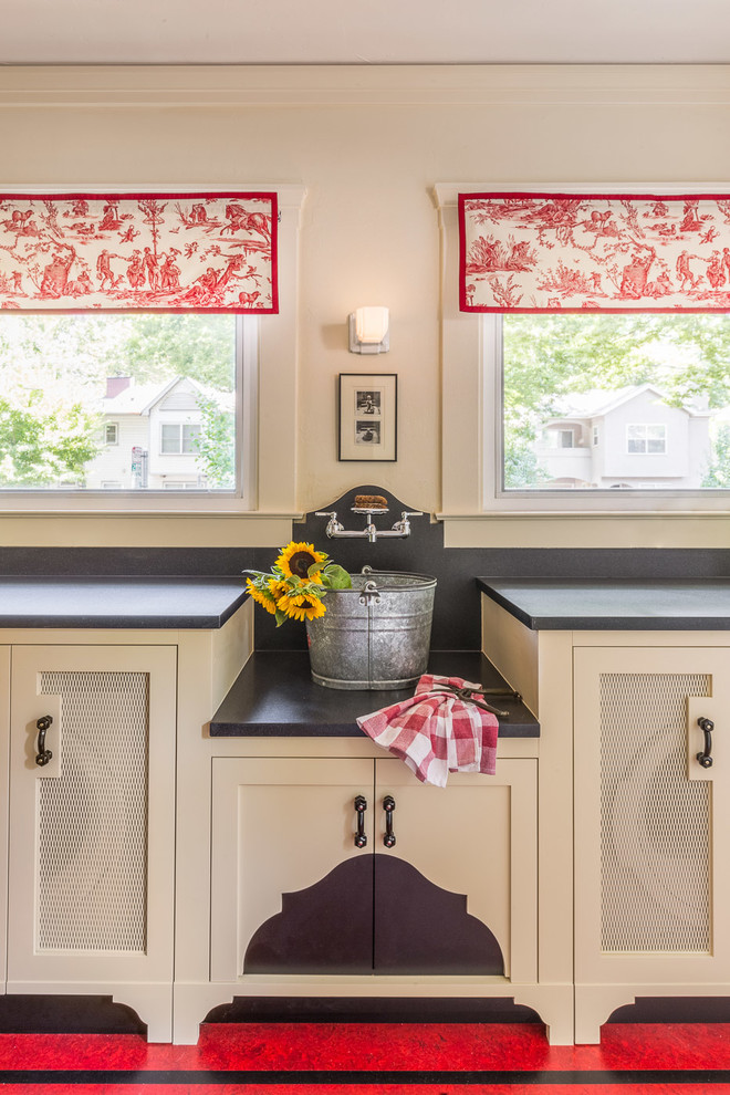 Amerikansk inredning av ett mellanstort svart svart kök, med en undermonterad diskho, skåp i shakerstil, gula skåp, granitbänkskiva, vitt stänkskydd, stänkskydd i keramik, vita vitvaror, linoleumgolv, en köksö och rött golv