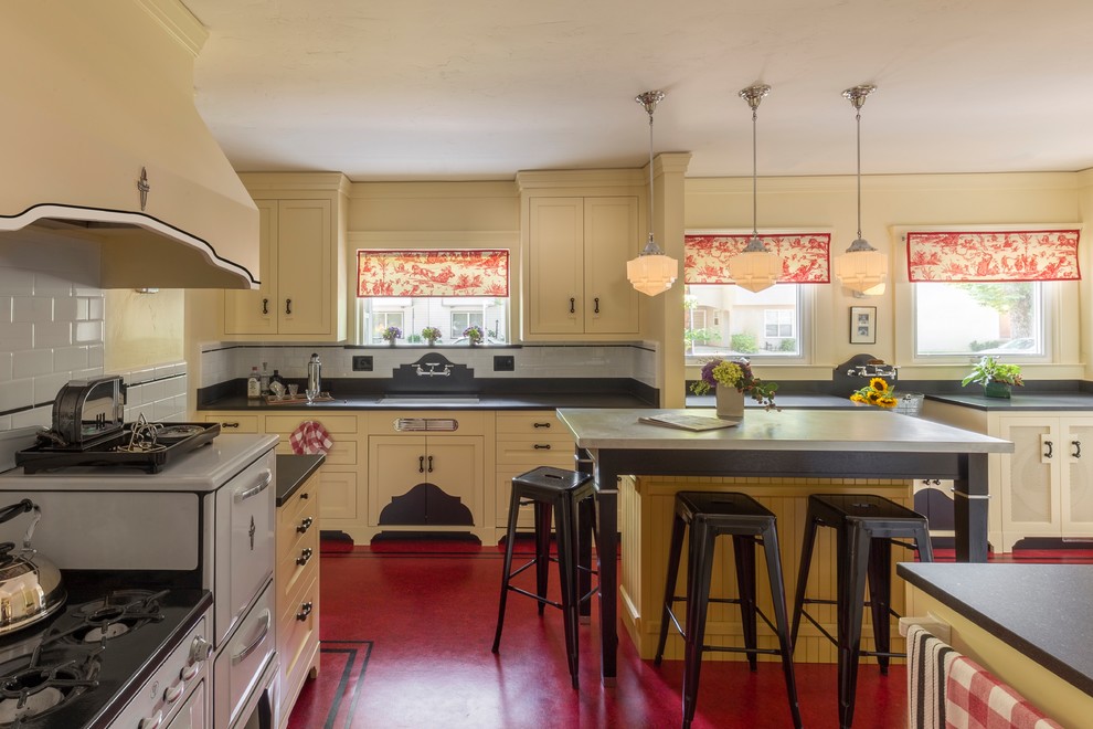 他の地域にある高級な中くらいなトラディショナルスタイルのおしゃれなキッチン (アンダーカウンターシンク、シェーカースタイル扉のキャビネット、黄色いキャビネット、御影石カウンター、白いキッチンパネル、セラミックタイルのキッチンパネル、白い調理設備、リノリウムの床、赤い床、黒いキッチンカウンター) の写真