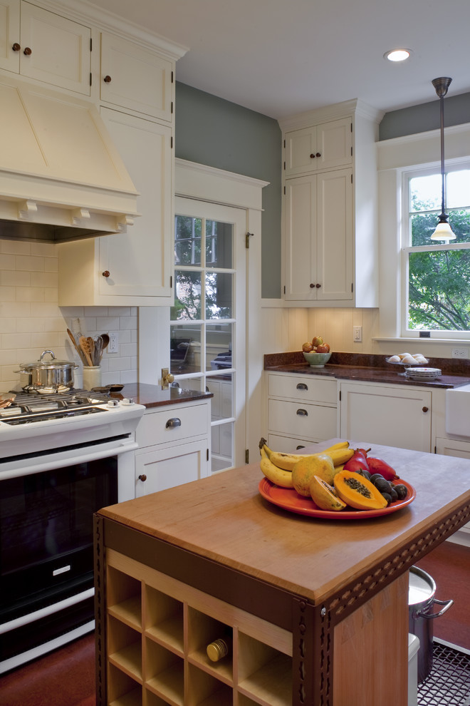 Bild på ett avskilt, mellanstort amerikanskt l-kök, med en rustik diskho, skåp i shakerstil, vita skåp, granitbänkskiva, vitt stänkskydd, stänkskydd i keramik, vita vitvaror, linoleumgolv och en köksö