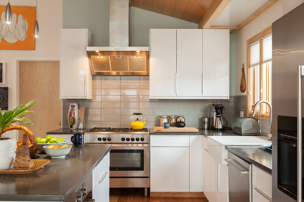 Mid-Century Küche in grau-weiß in L-Form mit Landhausspüle, flächenbündigen Schrankfronten, weißen Schränken, Quarzwerkstein-Arbeitsplatte, Küchenrückwand in Grau, Rückwand aus Keramikfliesen, Küchengeräten aus Edelstahl und Kücheninsel in San Francisco