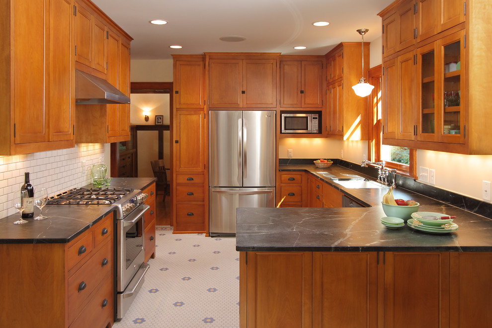 Kitchen - craftsman u-shaped kitchen idea in Minneapolis with recessed-panel cabinets, soapstone countertops, medium tone wood cabinets, white backsplash, subway tile backsplash and stainless steel appliances