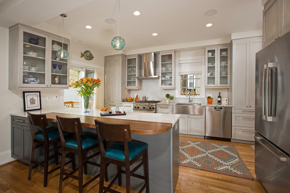 Mid-sized transitional galley medium tone wood floor eat-in kitchen photo in DC Metro with a farmhouse sink, shaker cabinets, gray cabinets, quartz countertops, white backsplash, glass tile backsplash, stainless steel appliances and no island