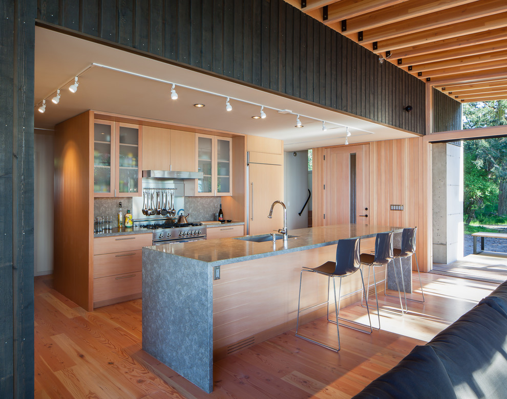 Idéer för ett modernt kök, med en undermonterad diskho, släta luckor, skåp i ljust trä, stänkskydd med metallisk yta, stänkskydd i metallkakel, integrerade vitvaror, mellanmörkt trägolv och en köksö