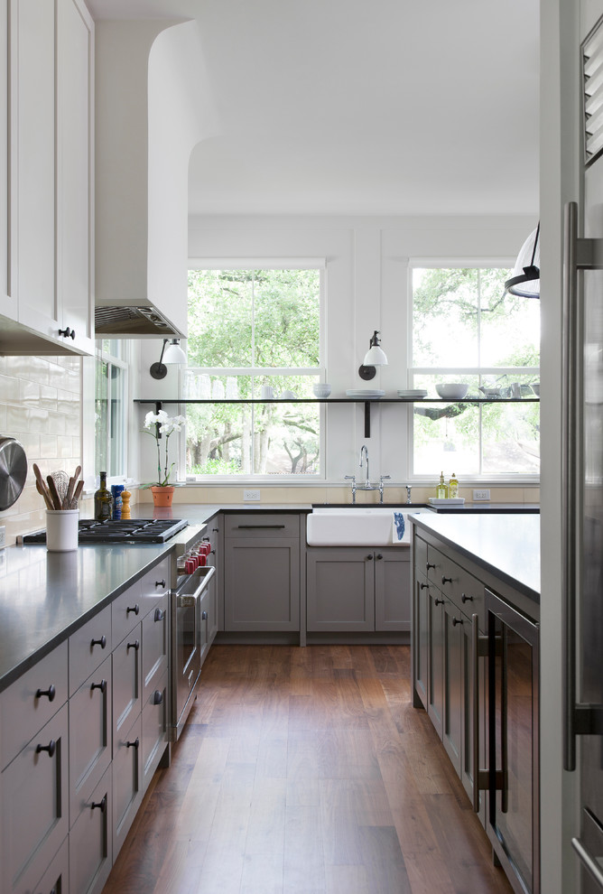 Inspiration for a large transitional galley medium tone wood floor kitchen remodel in Austin with shaker cabinets, gray cabinets, granite countertops, yellow backsplash and black countertops