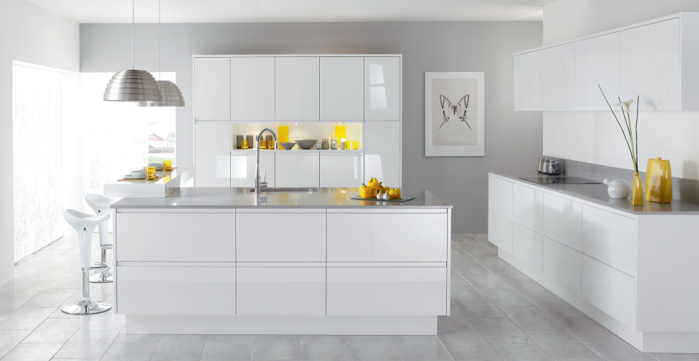 Immagine di una cucina minimalista con ante bianche, paraspruzzi bianco e top grigio