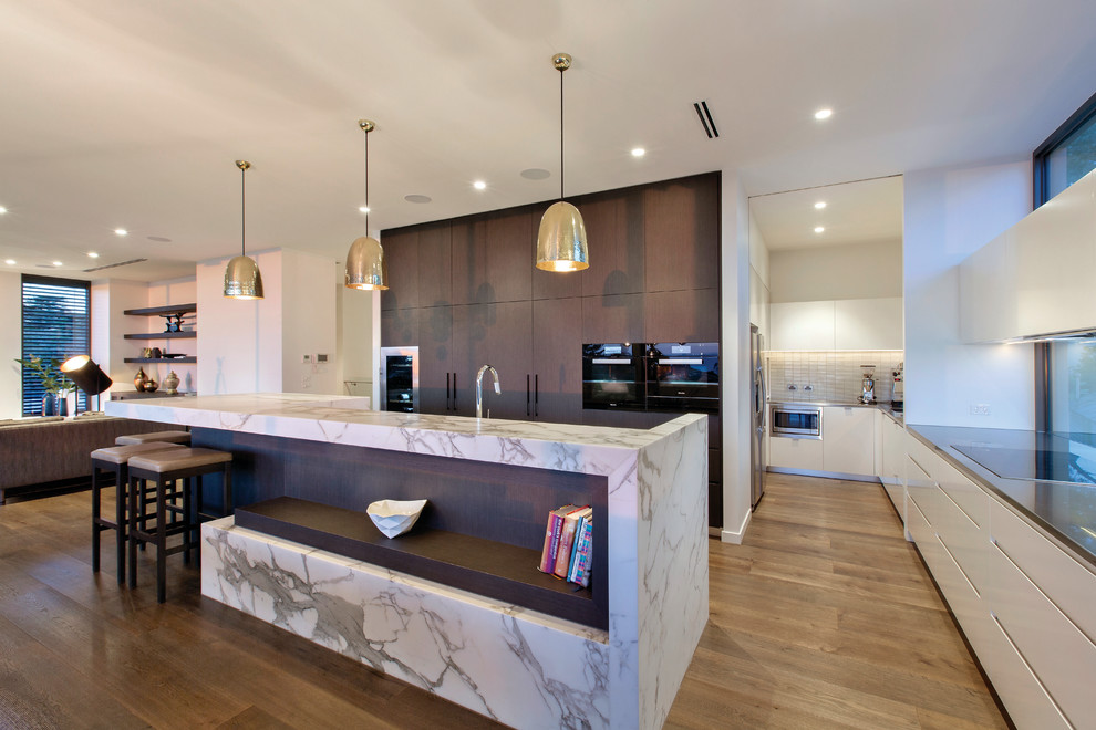 Offene Moderne Küche in L-Form mit flächenbündigen Schrankfronten, dunklen Holzschränken, braunem Holzboden und Kücheninsel in Melbourne
