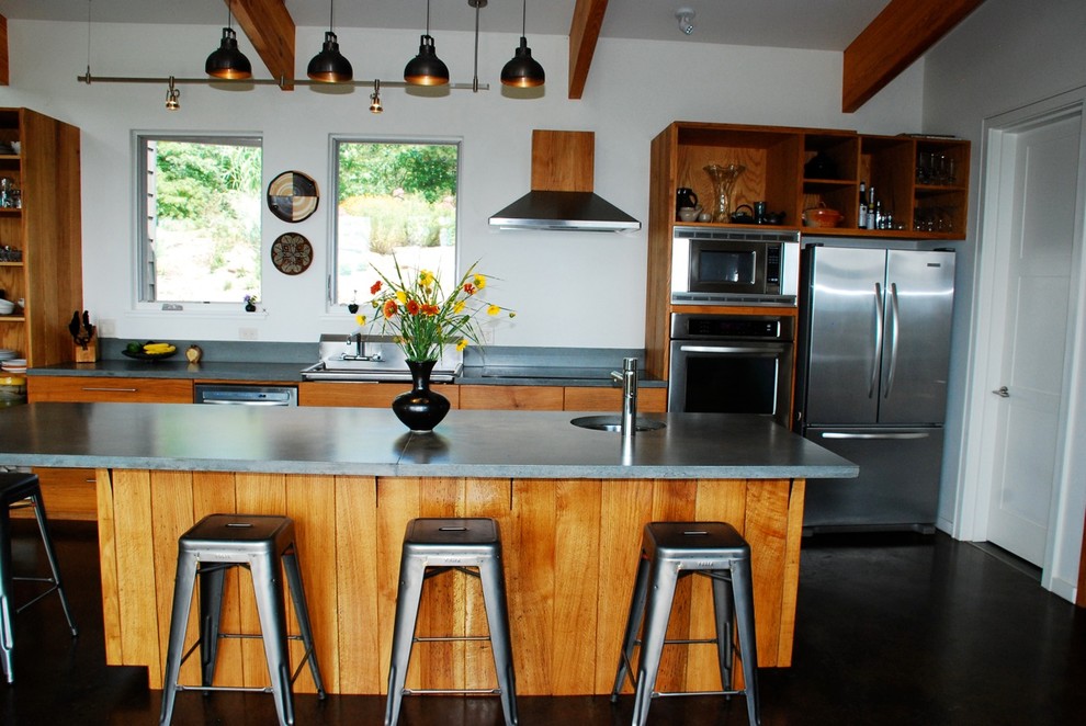 Einzeilige Moderne Küchenbar mit Küchengeräten aus Edelstahl, Betonarbeitsplatte, offenen Schränken und hellbraunen Holzschränken in Sonstige