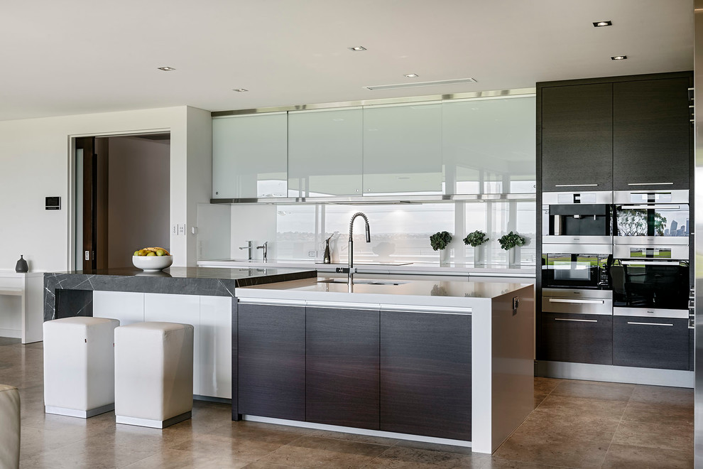 Design ideas for a contemporary kitchen in Perth with glass-front cabinets, stainless steel cabinets, white splashback, glass sheet splashback, stainless steel appliances and an island.