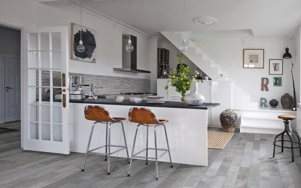 Идея дизайна: кухня в современном стиле с серым фартуком, полуостровом и серым полом