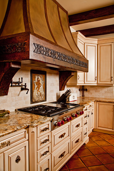 Example of a classic l-shaped kitchen design in Burlington with a farmhouse sink, raised-panel cabinets, wood countertops, multicolored backsplash, stainless steel appliances and two islands