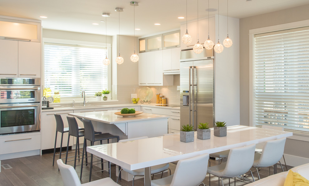 Mittelgroße Moderne Wohnküche in L-Form mit Unterbauwaschbecken, flächenbündigen Schrankfronten, weißen Schränken, Küchenrückwand in Grau, Küchengeräten aus Edelstahl, dunklem Holzboden und Kücheninsel in Vancouver