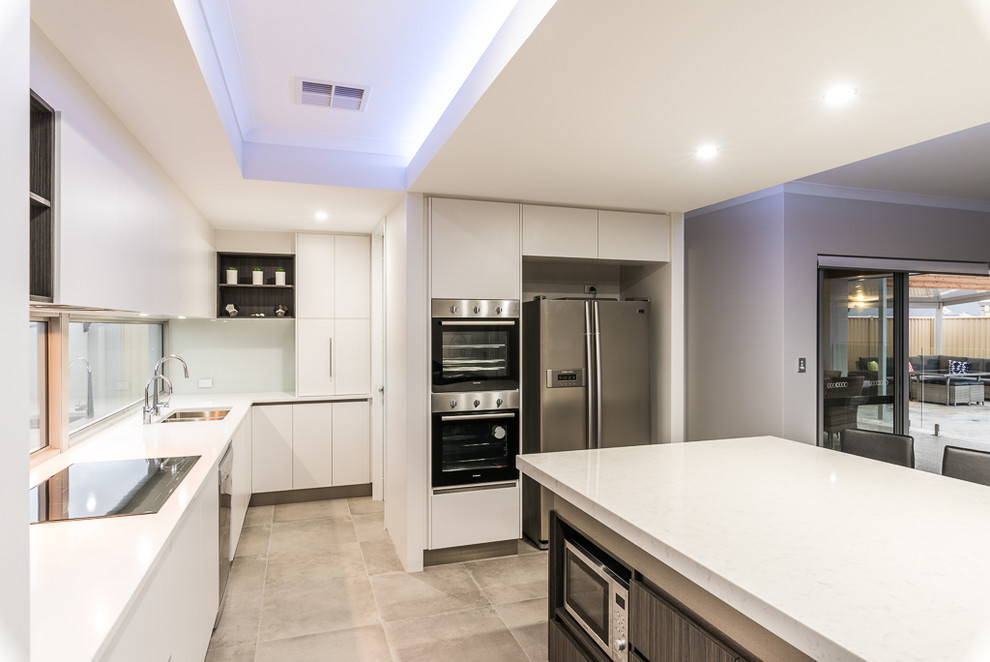Moderne Küche in L-Form mit Einbauwaschbecken, flächenbündigen Schrankfronten, weißen Schränken, Rückwand-Fenster, Küchengeräten aus Edelstahl, Keramikboden, Kücheninsel und buntem Boden in Perth