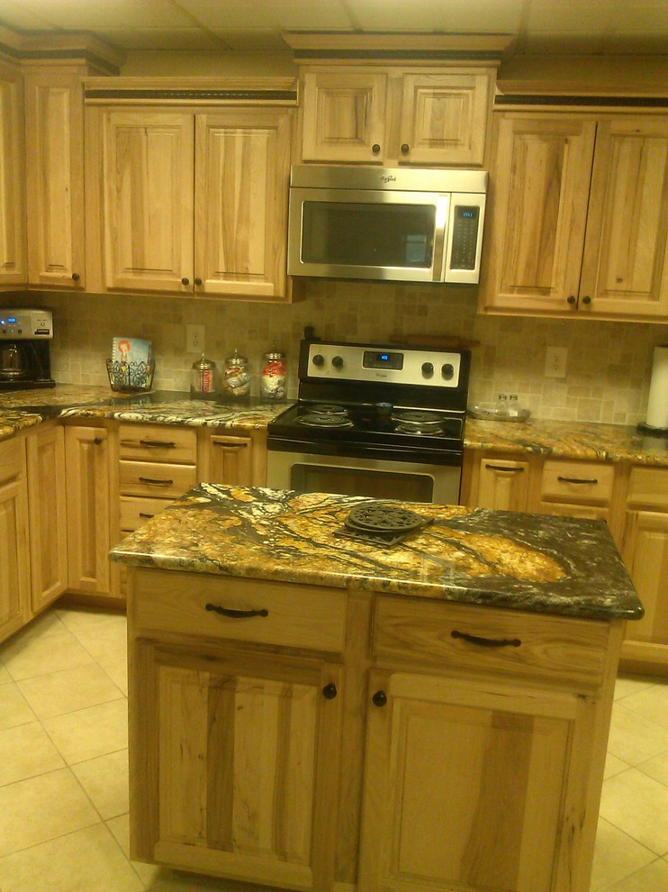 Foto på ett avskilt, mellanstort rustikt l-kök, med en dubbel diskho, luckor med infälld panel, skåp i ljust trä, granitbänkskiva, svart stänkskydd, stänkskydd i stenkakel, rostfria vitvaror, klinkergolv i keramik och en köksö