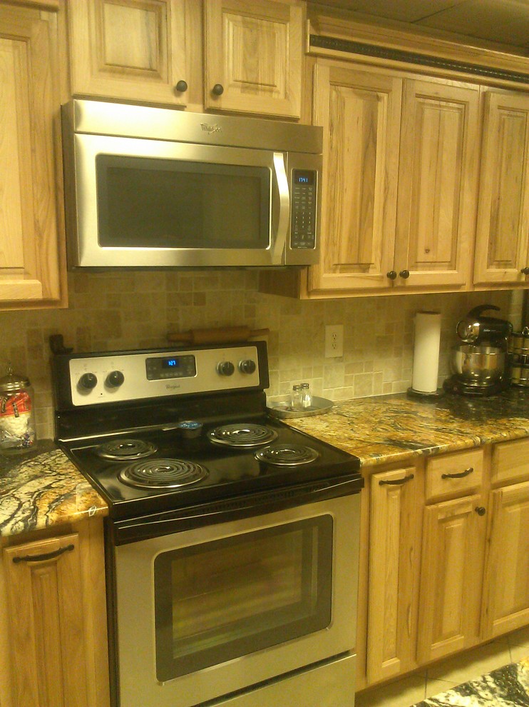 Exempel på ett mellanstort rustikt kök, med en dubbel diskho, luckor med upphöjd panel, skåp i ljust trä, granitbänkskiva, svart stänkskydd, stänkskydd i stenkakel, rostfria vitvaror, klinkergolv i keramik och en köksö