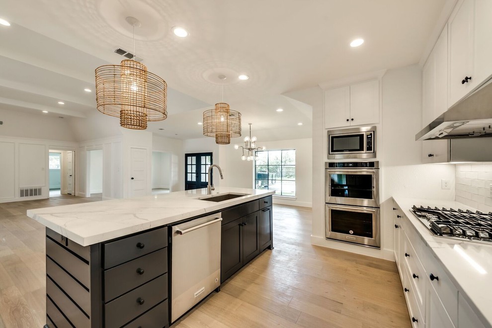 Inspiration for a contemporary light wood floor kitchen remodel in Dallas with an undermount sink, shaker cabinets, gray cabinets, quartz countertops, white backsplash, subway tile backsplash, stainless steel appliances, an island and white countertops