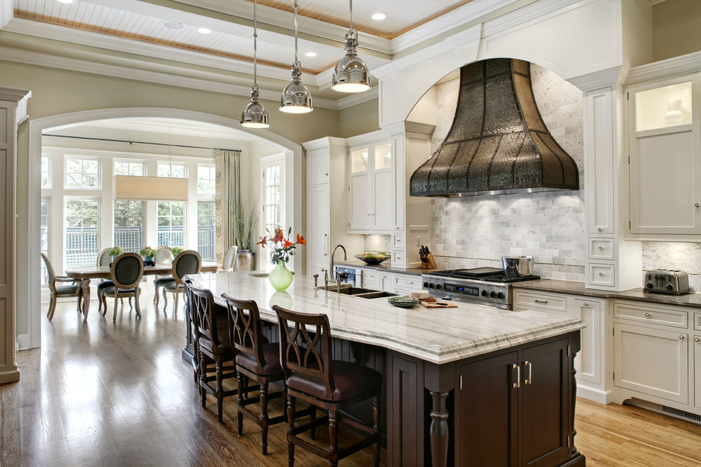 Eat-in kitchen - traditional eat-in kitchen idea in Chicago with a double-bowl sink, recessed-panel cabinets, white cabinets, white backsplash, stone tile backsplash and stainless steel appliances