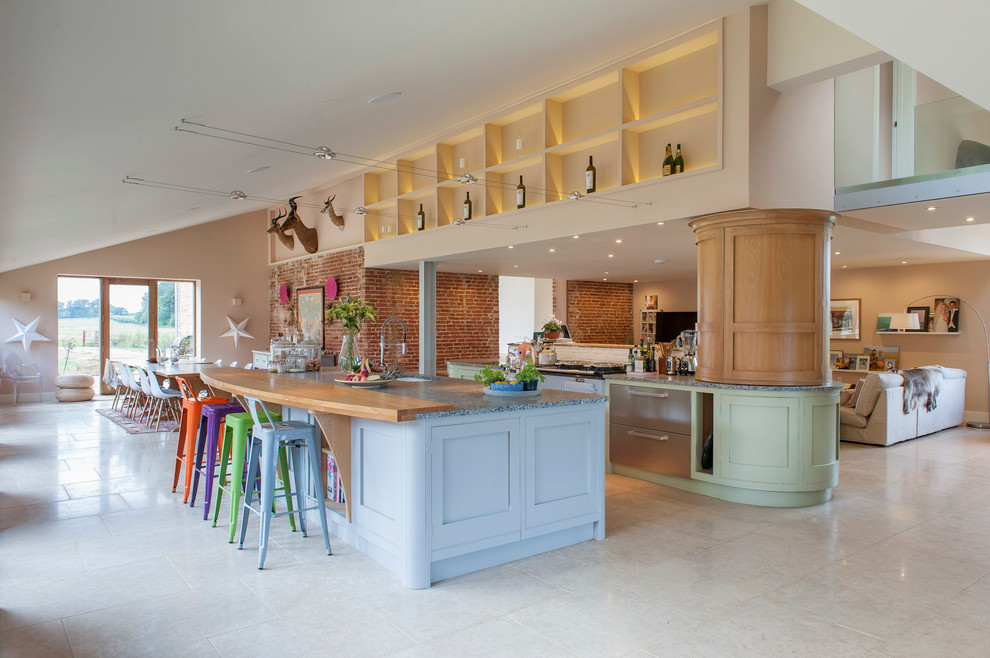 Foto di una cucina tradizionale di medie dimensioni con lavello integrato, ante in stile shaker, ante blu, top in granito, elettrodomestici in acciaio inossidabile e pavimento in gres porcellanato