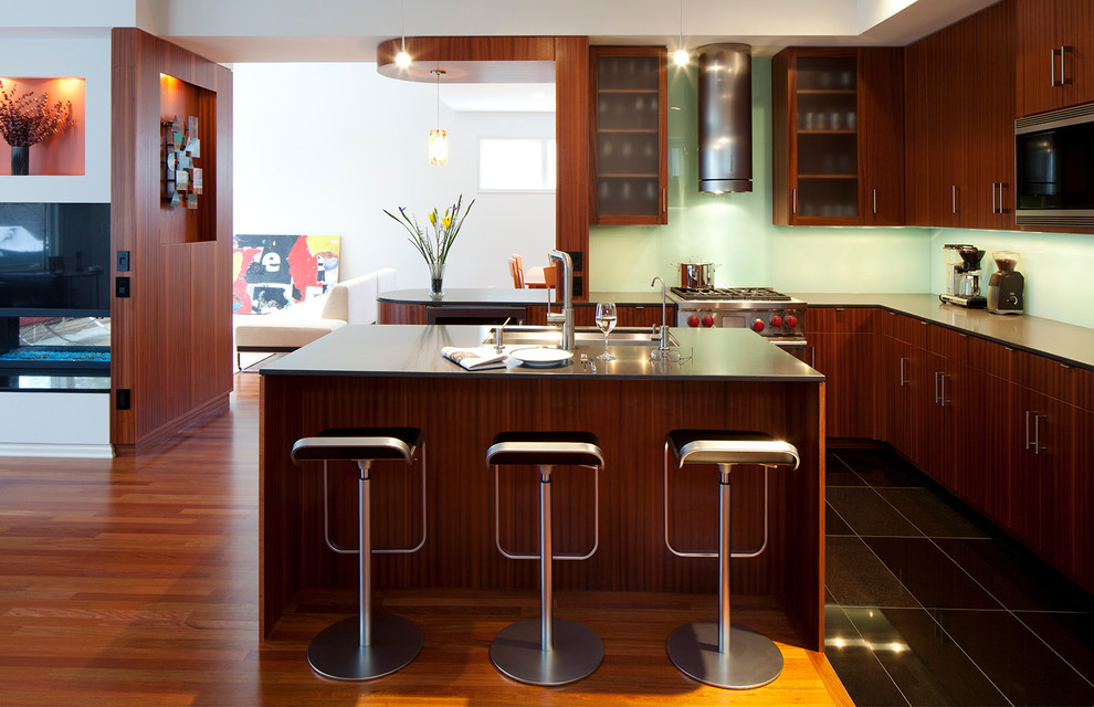 Diseño de cocina contemporánea abierta con armarios con paneles lisos, puertas de armario de madera en tonos medios y electrodomésticos de acero inoxidable