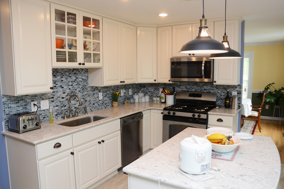 Inredning av ett klassiskt mellanstort kök, med en enkel diskho, luckor med upphöjd panel, vita skåp, bänkskiva i kvarts, blått stänkskydd, rostfria vitvaror, en köksö och vitt golv