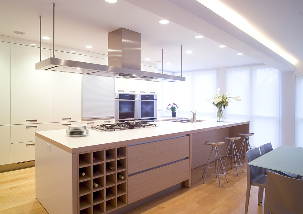 Idéer för mellanstora funkis linjära vitt kök och matrum, med en nedsänkt diskho, släta luckor, vita skåp, laminatbänkskiva, integrerade vitvaror, ljust trägolv, en köksö och gult golv