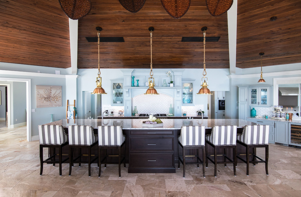 Idee per un cucina con isola centrale stile marino con ante di vetro, ante blu, paraspruzzi multicolore, pavimento beige e top grigio