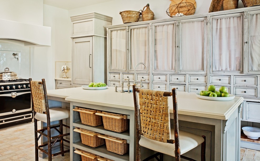 Diseño de cocina tradicional con puertas de armario blancas, electrodomésticos negros y barras de cocina