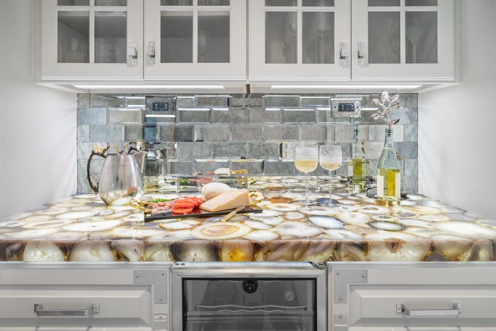 Example of a mid-sized transitional kitchen pantry design in New York with raised-panel cabinets, white cabinets, quartzite countertops, multicolored backsplash, mirror backsplash and an island
