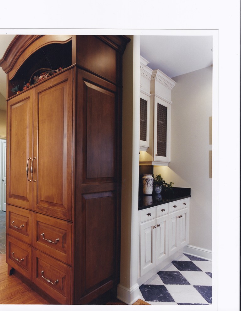 Example of a large classic u-shaped medium tone wood floor eat-in kitchen design in Chicago with an undermount sink, raised-panel cabinets, white cabinets, granite countertops, multicolored backsplash, stone tile backsplash and paneled appliances
