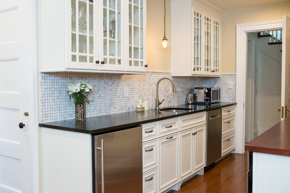Exempel på ett stort klassiskt kök, med en undermonterad diskho, luckor med infälld panel, vita skåp, träbänkskiva, grått stänkskydd, stänkskydd i marmor, rostfria vitvaror och mellanmörkt trägolv