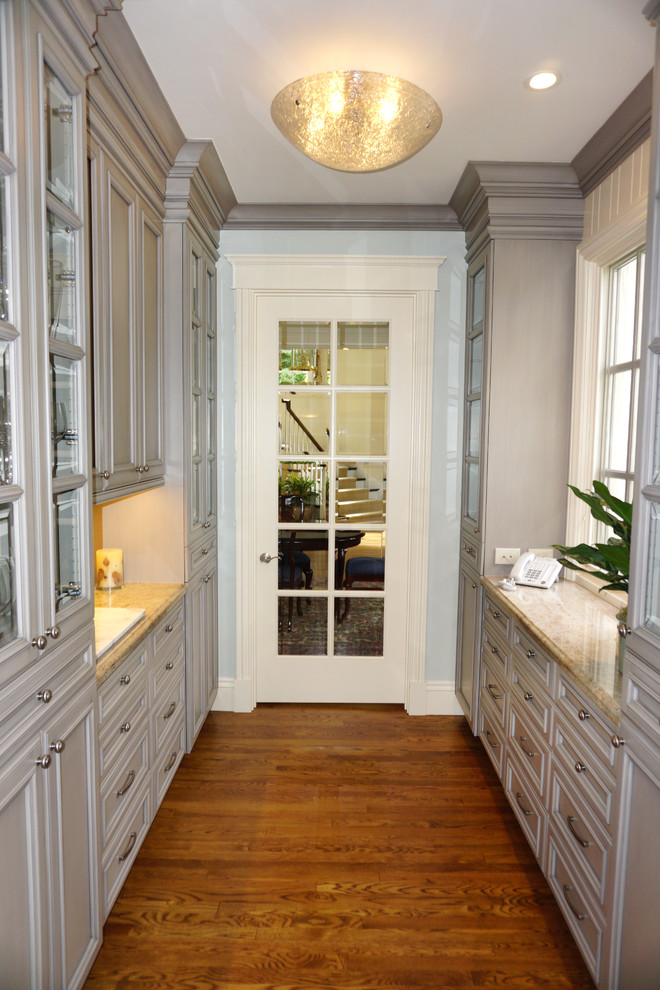 Exempel på ett klassiskt kök, med en enkel diskho, luckor med upphöjd panel, grå skåp, granitbänkskiva, gult stänkskydd, stänkskydd i keramik, rostfria vitvaror, mörkt trägolv och brunt golv