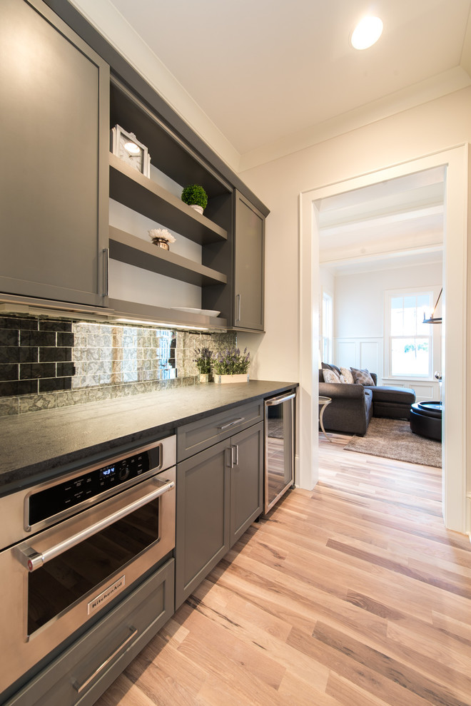 Foto de cocina de estilo americano de tamaño medio con electrodomésticos de acero inoxidable, suelo de madera clara y suelo beige