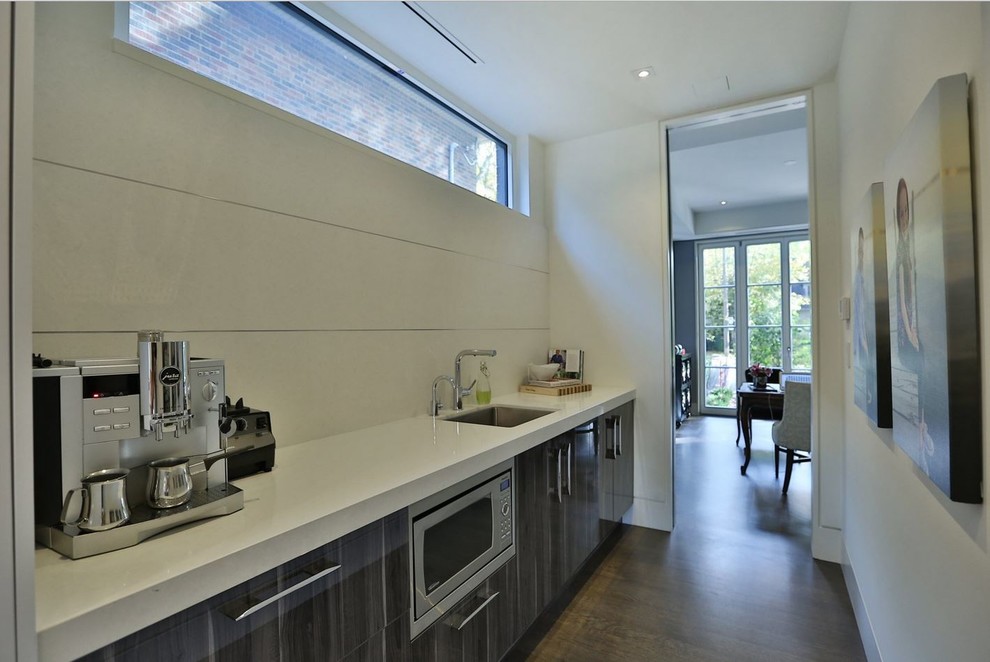 Foto di una cucina minimal di medie dimensioni con lavello sottopiano, ante lisce, ante bianche, paraspruzzi bianco, elettrodomestici in acciaio inossidabile e parquet scuro