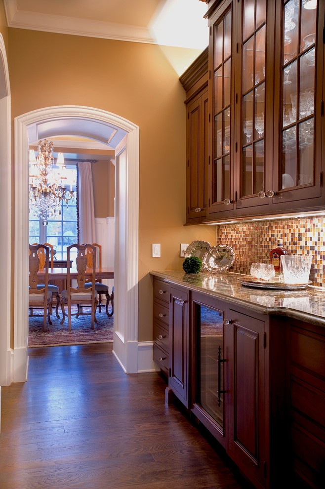 Example of a large classic u-shaped dark wood floor and brown floor eat-in kitchen design in Chicago with multicolored backsplash, an undermount sink, raised-panel cabinets, beige cabinets, granite countertops, porcelain backsplash, stainless steel appliances and an island