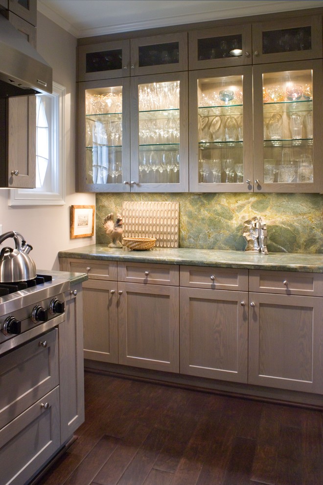 Immagine di una grande cucina moderna con ante di vetro, ante grigie, top in granito, paraspruzzi verde, elettrodomestici in acciaio inossidabile, paraspruzzi in lastra di pietra e parquet scuro