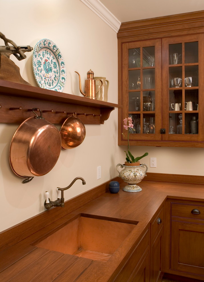 Immagine di una cucina ad U classica di medie dimensioni con ante di vetro, top in legno, lavello a vasca singola, ante in legno bruno e paraspruzzi bianco
