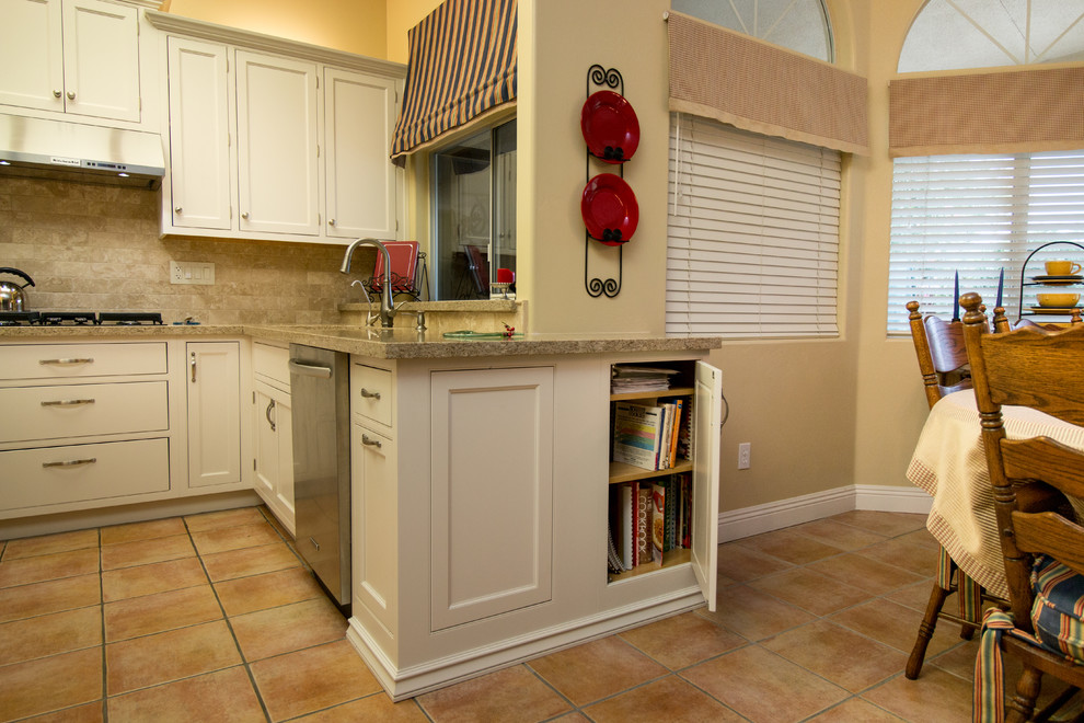 Klassisk inredning av ett mycket stort beige beige kök och matrum, med en undermonterad diskho, luckor med profilerade fronter, gula skåp, bänkskiva i kvarts, beige stänkskydd, stänkskydd i travertin, rostfria vitvaror och orange golv