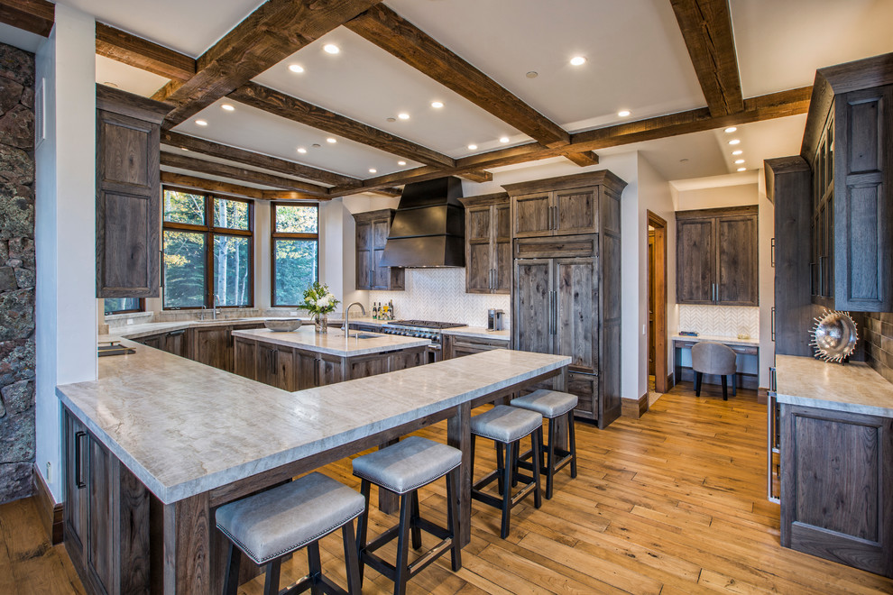 Inspiration for a large rustic l-shaped light wood floor and brown floor eat-in kitchen remodel in Denver with an undermount sink, shaker cabinets, distressed cabinets, laminate countertops, white backsplash, mosaic tile backsplash, paneled appliances and two islands