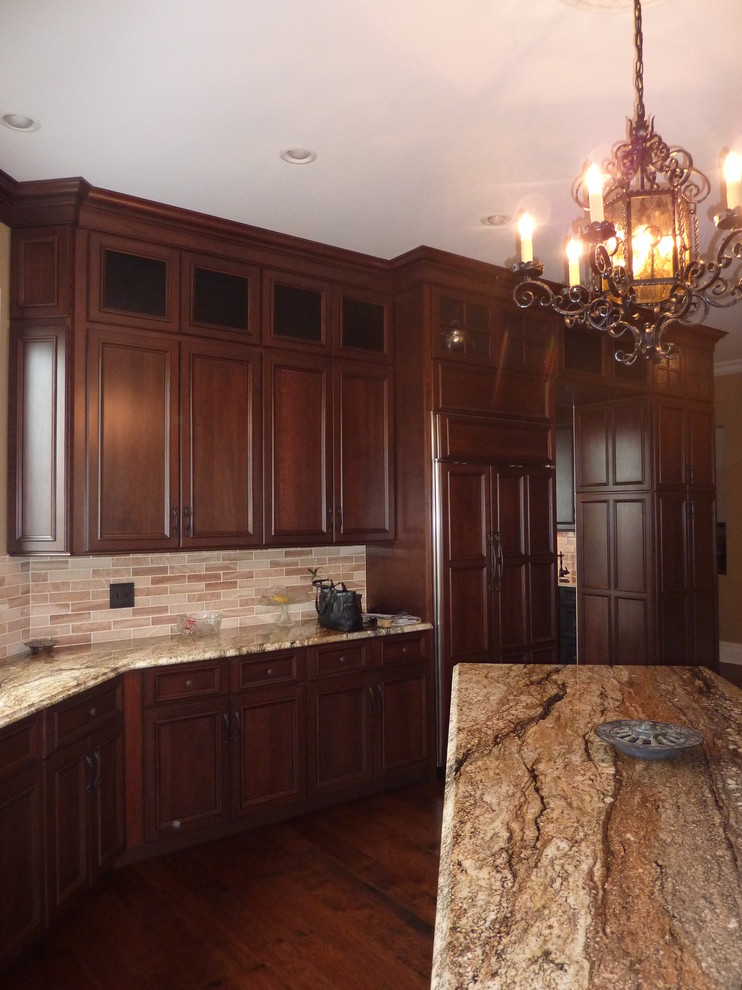 Elegant eat-in kitchen photo in St Louis with recessed-panel cabinets, dark wood cabinets, granite countertops and paneled appliances