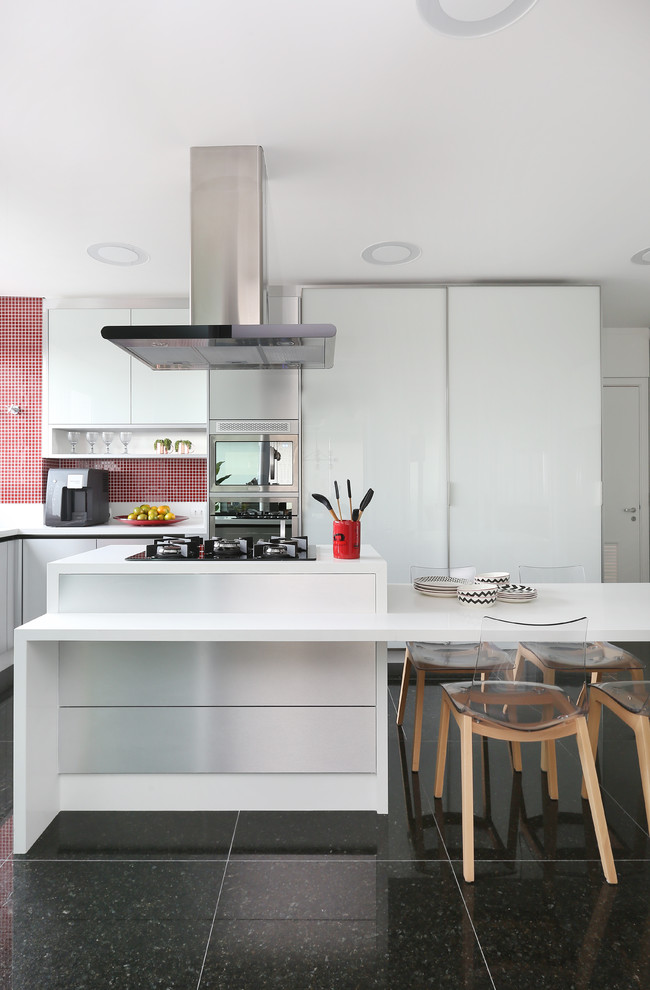Inspiration for a contemporary l-shaped kitchen in Other with flat-panel cabinets, white cabinets, red splashback, stainless steel appliances, an island, grey floors and white worktops.