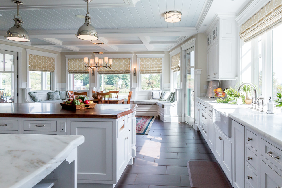 Inspiration for a huge coastal galley porcelain tile eat-in kitchen remodel in New York with a farmhouse sink, beaded inset cabinets, white cabinets, quartzite countertops, gray backsplash, stone slab backsplash, stainless steel appliances and two islands