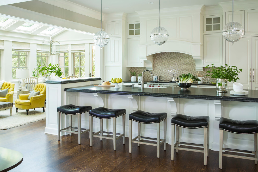 Immagine di una cucina ad ambiente unico chic con ante con riquadro incassato, ante bianche, paraspruzzi beige e top nero