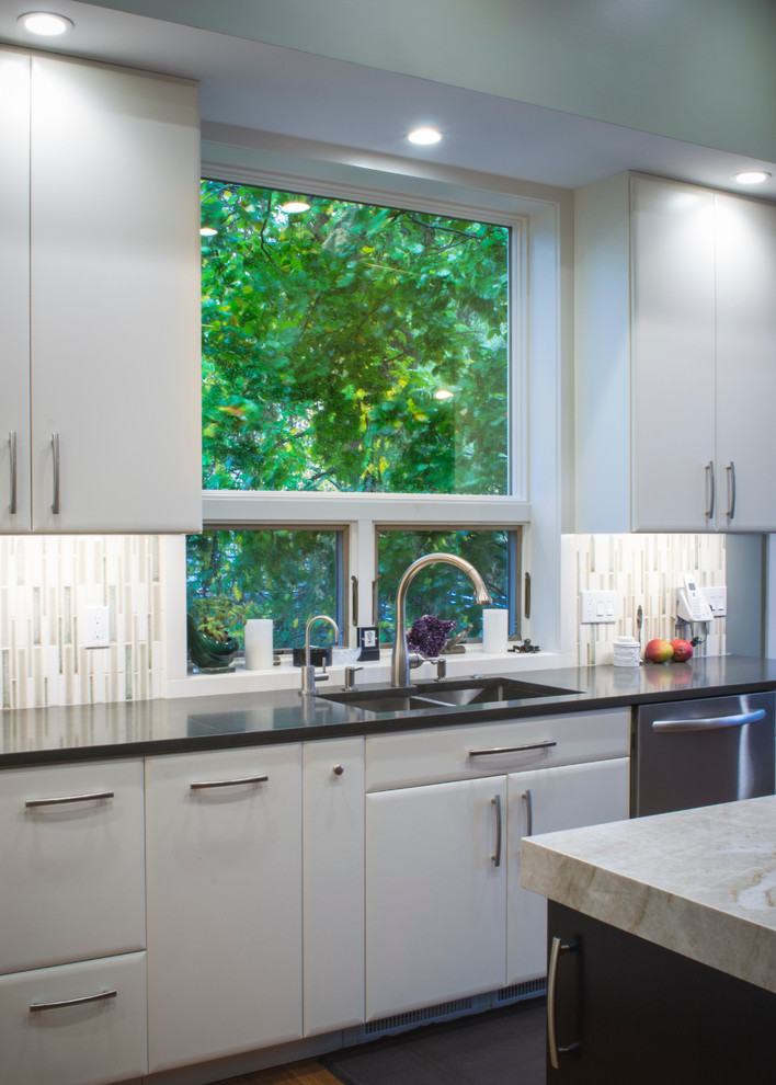 Example of a mid-sized trendy l-shaped bamboo floor eat-in kitchen design in Cleveland with an undermount sink, flat-panel cabinets, white cabinets, quartzite countertops, beige backsplash, mosaic tile backsplash, stainless steel appliances and an island