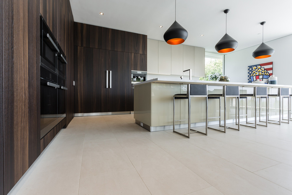 Example of a large trendy l-shaped ceramic tile and beige floor eat-in kitchen design in Los Angeles with a single-bowl sink, flat-panel cabinets, dark wood cabinets, quartz countertops, white backsplash, glass sheet backsplash, black appliances and an island