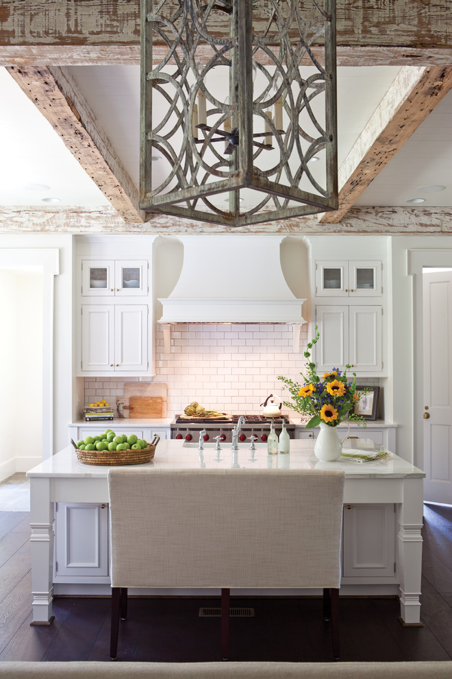 Eat-in kitchen - mid-sized cottage single-wall dark wood floor and brown floor eat-in kitchen idea in DC Metro with a farmhouse sink, beaded inset cabinets, white cabinets, marble countertops, white backsplash, subway tile backsplash, an island and white countertops