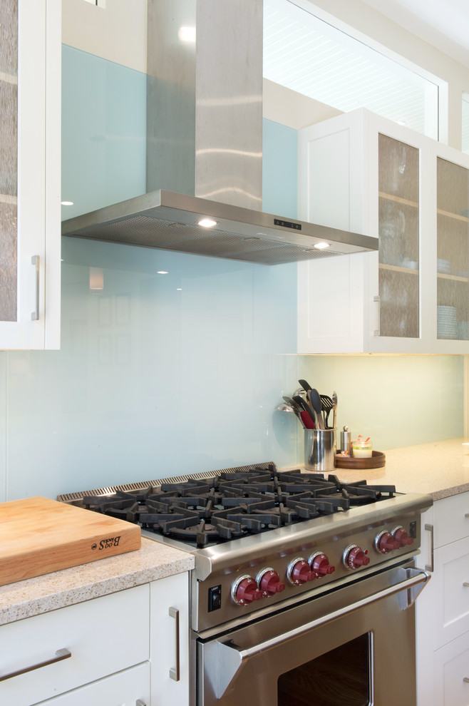 Esempio di una cucina minimal di medie dimensioni con lavello a vasca singola, ante in stile shaker, ante bianche, top in quarzo composito, paraspruzzi blu, paraspruzzi con lastra di vetro, elettrodomestici in acciaio inossidabile e parquet chiaro