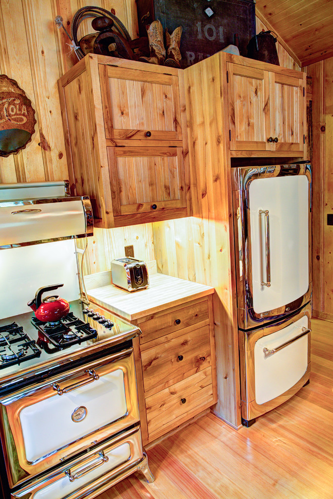 Inredning av ett rustikt mellanstort kök, med en rustik diskho, luckor med profilerade fronter, skåp i ljust trä, träbänkskiva, rostfria vitvaror och ljust trägolv