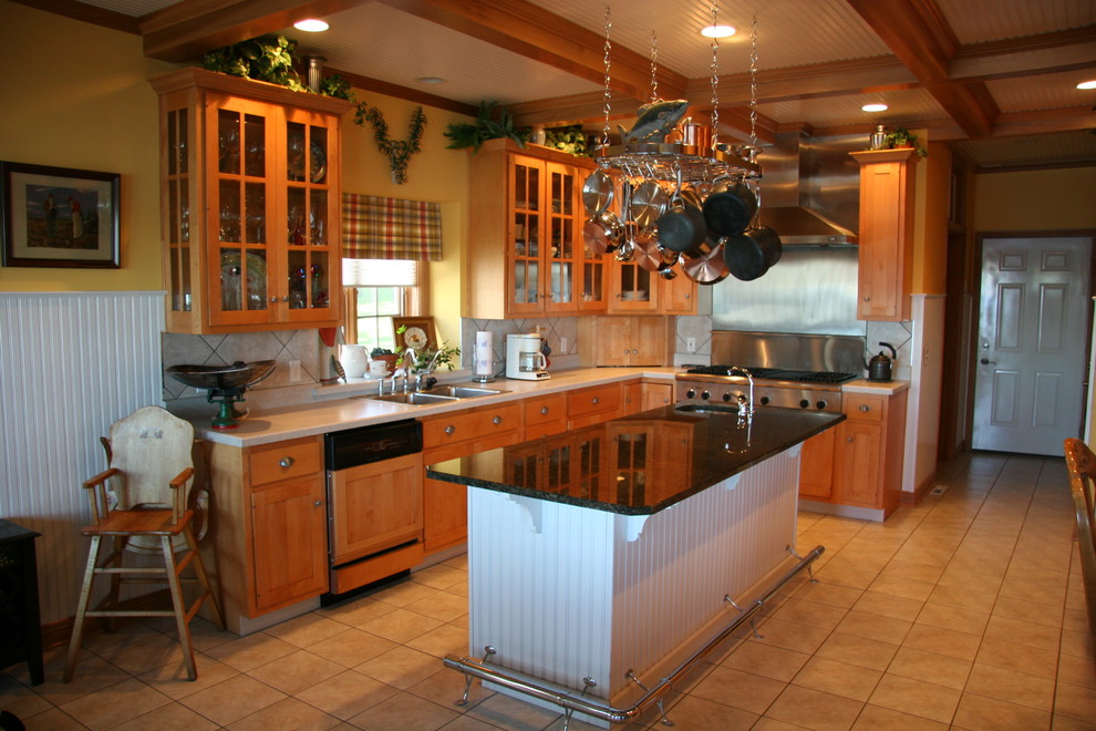 This is an example of a large rustic l-shaped enclosed kitchen in Indianapolis with a double-bowl sink, glass-front cabinets, medium wood cabinets, granite worktops, beige splashback, ceramic splashback, stainless steel appliances, ceramic flooring and an island.